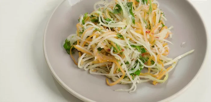 Cho nộm ra đĩa, rắc rau kinh giới và đậu phộng còn lại lên trên.