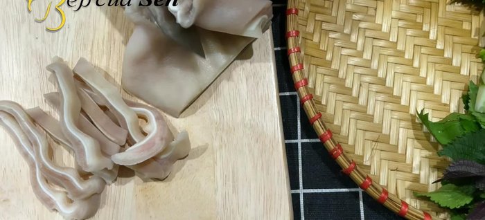 Thái tai heo thành miếng vừa ăn và thưởng thức cùng rau sống và nước chấm.