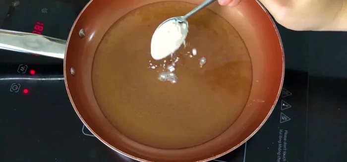 Làm nóng chảo dầu. Thêm 1 muỗng canh bột bắp (hoặc bột mì) vào chảo dầu nóng để cá không bị bắn dầu khi chiên.