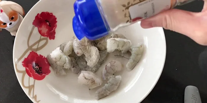 Chuẩn bị nhân bánh: Tôm lột vỏ, cắt nhỏ, trộn với tiêu, bột tỏi.