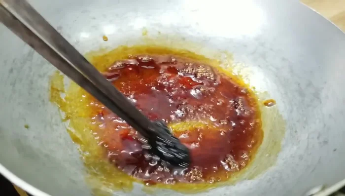 Thêm nước mắm, dầu hào, hạt nêm, sữa đặc, dầu màu điều, mỡ, mật ong vào hỗn hợp caramen, khuấy đều. (211.54)