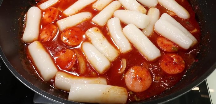 Cho bánh gạo vào sốt, đun thêm 1-2 phút cho bánh ngấm sốt.