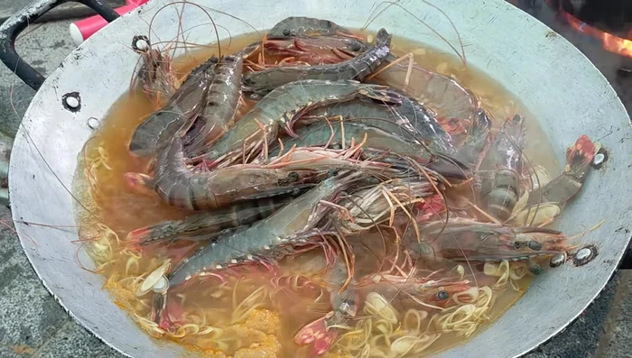 Cho tôm vào luộc.