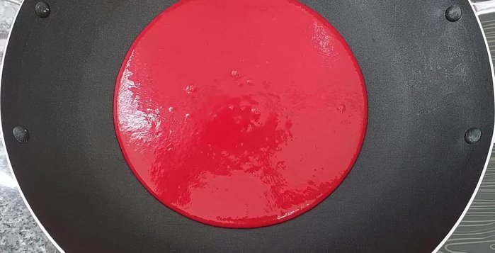 Cho 400ml hỗn hợp nước cốt gấc và 2 muỗng canh dầu ăn vào chảo, khuấy đều và đun sôi.