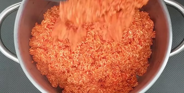 Cho nếp đã xào vào xửng hấp, dàn đều và tạo lỗ nhỏ ở giữa để xôi chín đều.
