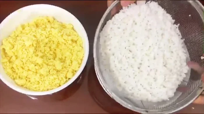 Đổ nếp ra rổ cho ráo nước. Trộn 1/3 đậu xanh xay nhuyễn vào nếp để tạo màu.