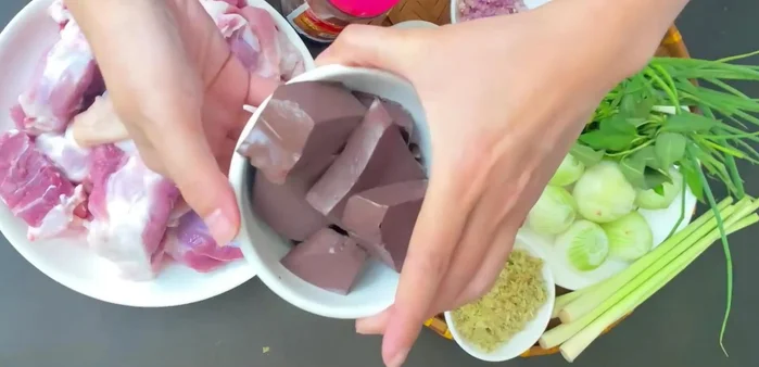 Mua huyết heo đã luộc chín, cắt miếng vừa ăn, trụng sơ qua nước sôi 4-5 phút cho sạch.