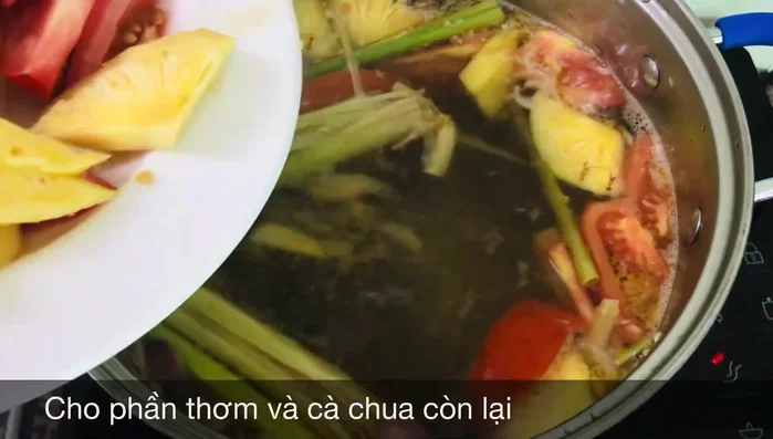 Cho ½ trái thơm và cà chua vào nồi khi nước sôi. (210.68)