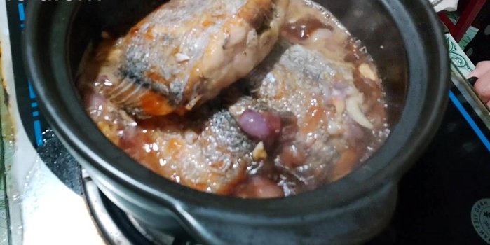 Đun nhỏ lửa, đậy nắp, kho khoảng 10 phút cho cá thấm gia vị (373.07).