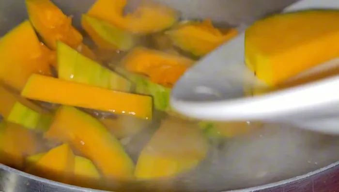 Khi thịt chín, cho bí đỏ vào nồi.