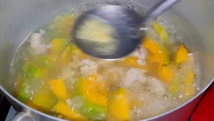 Cho hành lá vào khi bí đã chín, tắt bếp.