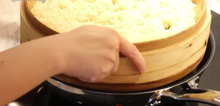 Hấp nếp trong 15 phút ở lửa trung bình (539.16). Trộn đều, cho 1/2 lượng thịt chim cút xào vào trộn đều (570.76).