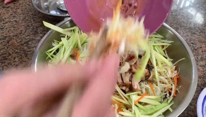 Thêm xoài bằm (nếu không dùng xoài thì thêm chanh). Trộn đều. Thêm rau răm, hành phi, đậu phộng rang, mè rang.
