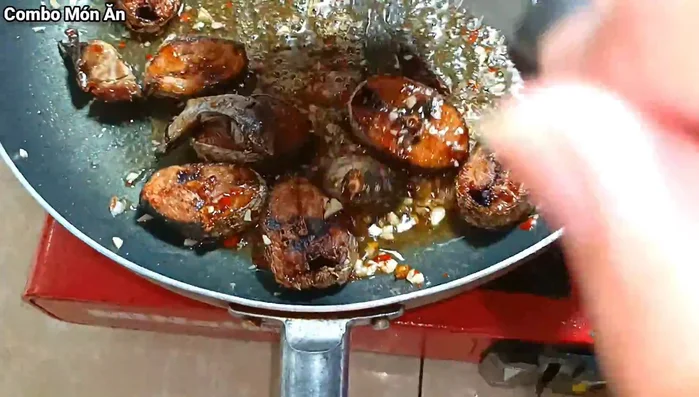 Cho cá đã chiên vào chảo nước mắm, đảo đều cho cá thấm gia vị.