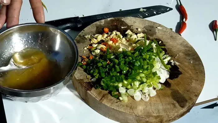Làm mỡ hành: Cho hành lá, ớt, tỏi băm nhỏ vào chén, thêm chút nước mắm, dầu ăn/dầu dừa, trộn đều. (299.02)