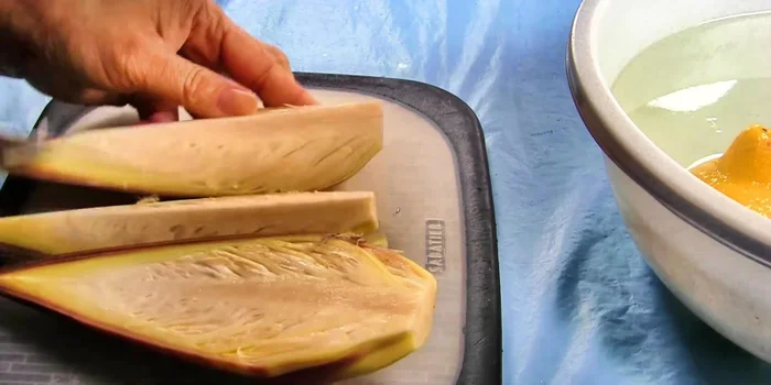 Cắt bắp chuối, ngâm ngay vào thau nước muối chanh. Úp mặt trong của bắp chuối xuống dưới. Tước bỏ những cọng già và nhụy bên trong.