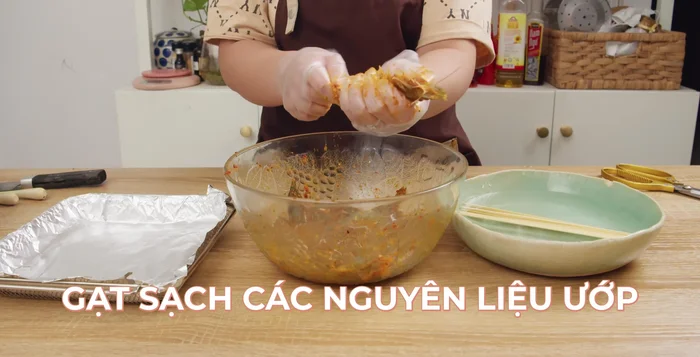 Làm sạch cặn gia vị trên bề mặt tôm để tránh bị cháy khi nướng.
