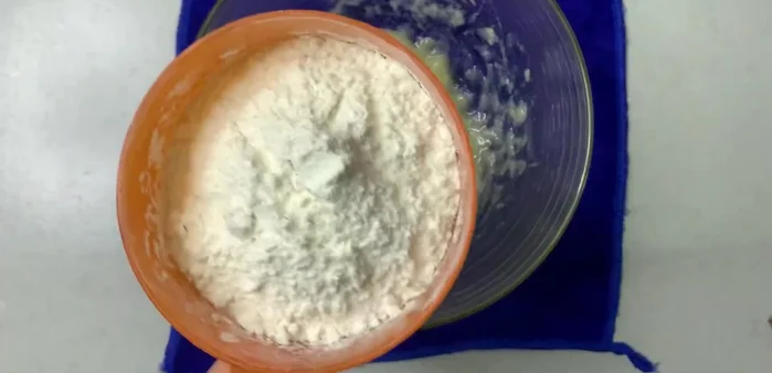 Cho chuối nghiền vào tô, thêm bột mì, dầu ăn (10g), trộn đều đến khi tạo thành khối mềm dẻo.