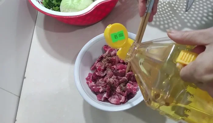 Ướp thịt bò với 1/2 thìa bột canh, 1 chút hạt tiêu và đường. Thêm dầu ăn, trộn đều và ướp khoảng 15 phút (63.71).