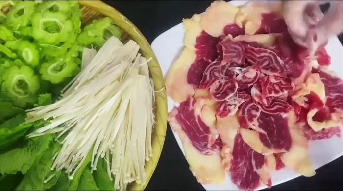 Cắt thịt bò lát mỏng, trang trí với hành tây và hành ngò.
