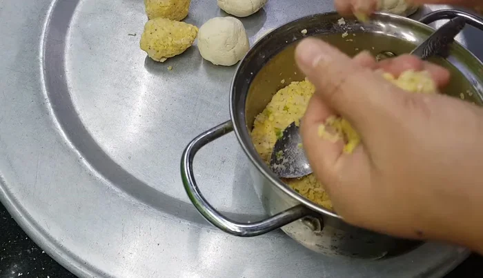 Gói bánh: Lấy một ít bột sắn dàn mỏng, cho nhân vào giữa rồi gói lại thành hình trụ. (447.83)