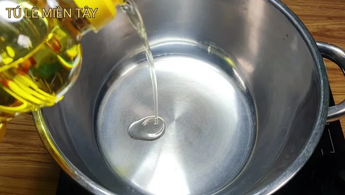 Phi thơm tỏi: Cho dầu ăn vào nồi, phi thơm tỏi băm và ớt.