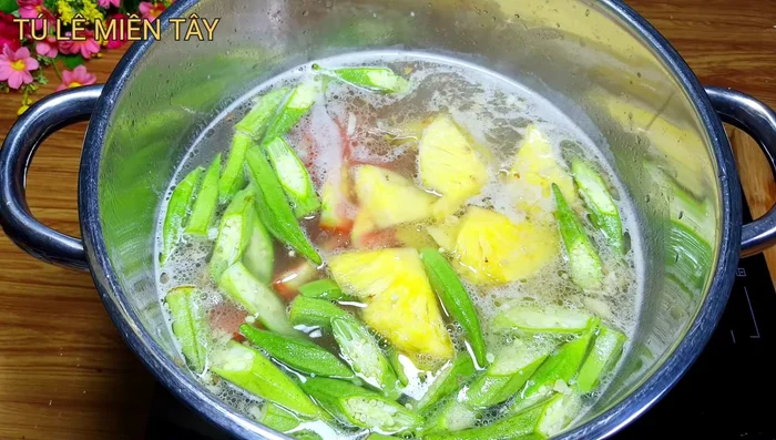 Thêm nguyên liệu: Cho cà chua, đậu bắp, thơm, bạc hà vào nồi. Nêm nếm gia vị: đường, nước mắm, bột ngọt, muối.