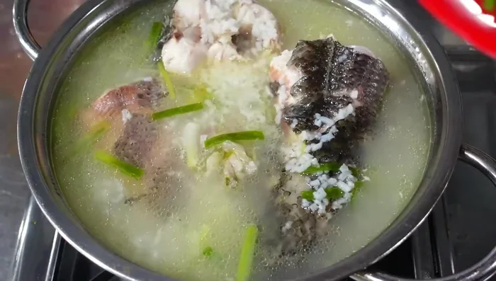 Cho hành lá, ngò rí, tỏi phi lên trên mặt cháo. Thêm tiêu.