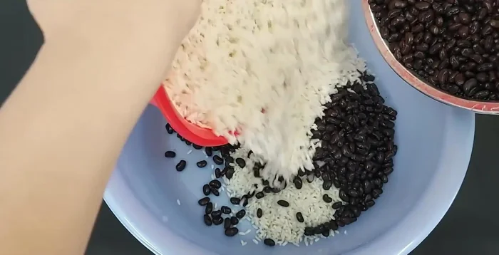 Trộn đều đậu đen với gạo nếp đã ngâm, thêm 3 muỗng canh dầu ăn.