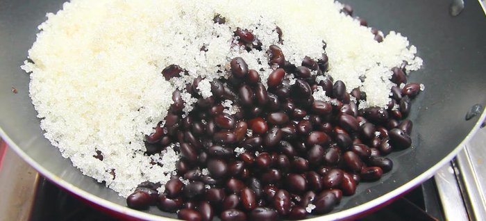 Cho đậu đen đã luộc vào chảo, thêm 200g đường, rim trên lửa nhỏ khoảng 10 phút cho đến khi đường tan và đậu thấm (170.76, 197.9).