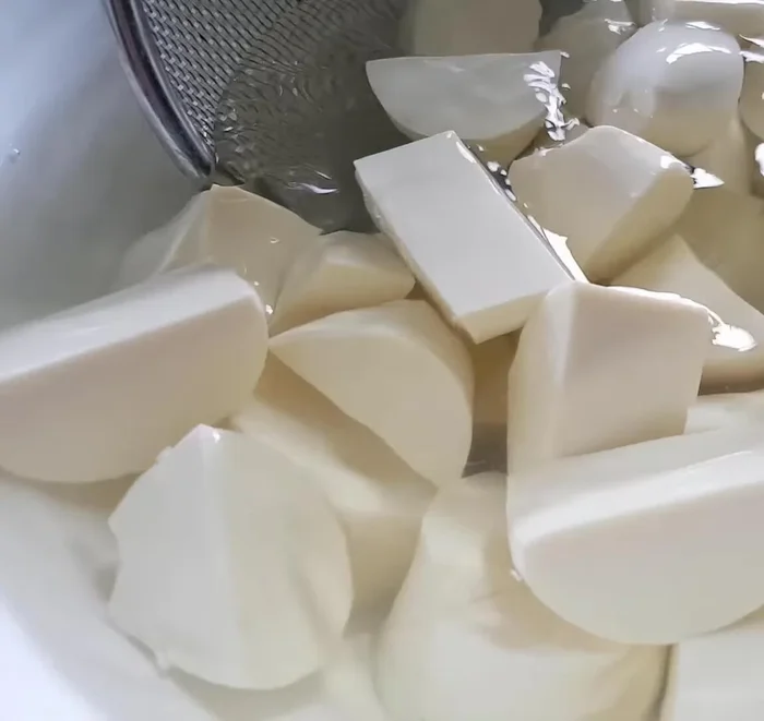Cho đậu hũ non đã ngâm vào nồi canh.
