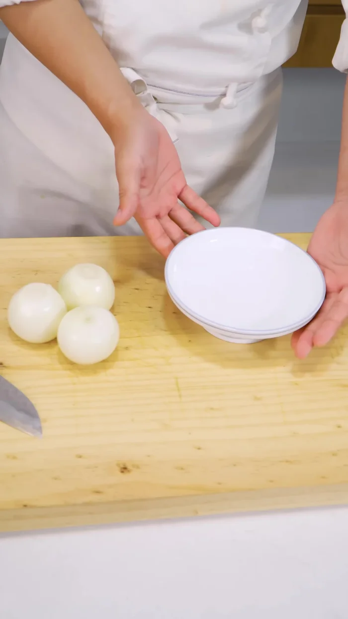 Thái mỏng hành tây. Nếu muốn hạn chế cay mắt, ngâm hành tây vào tô nước.