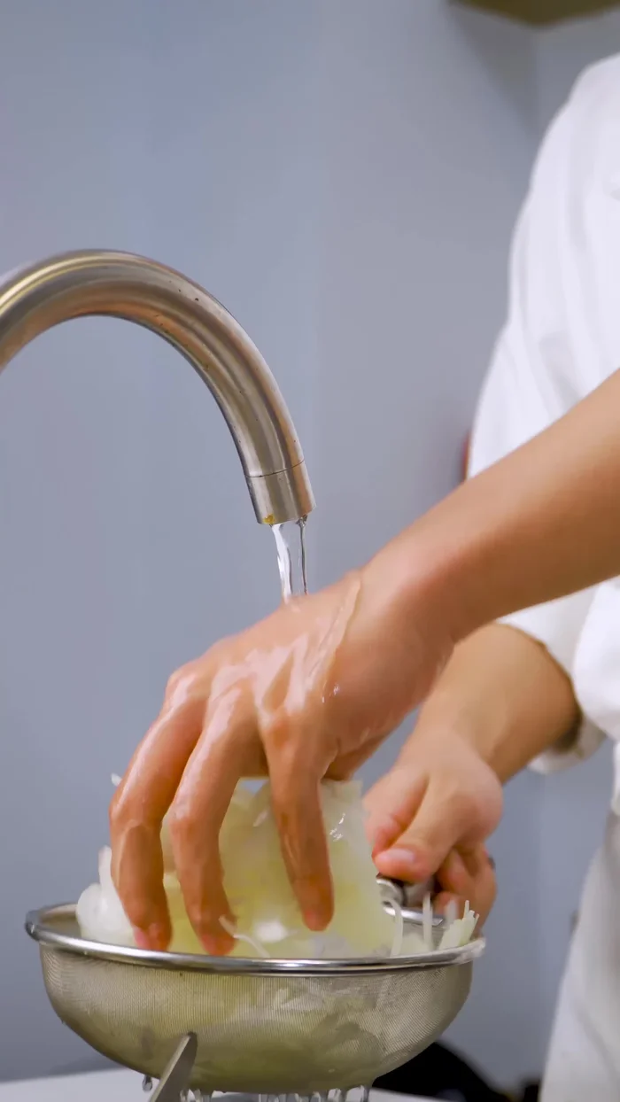 Rửa sạch hành tây nhiều lần (3-4 lần) cho bớt hăng, sau đó ngâm vào nước đá để hành giòn và trong.
