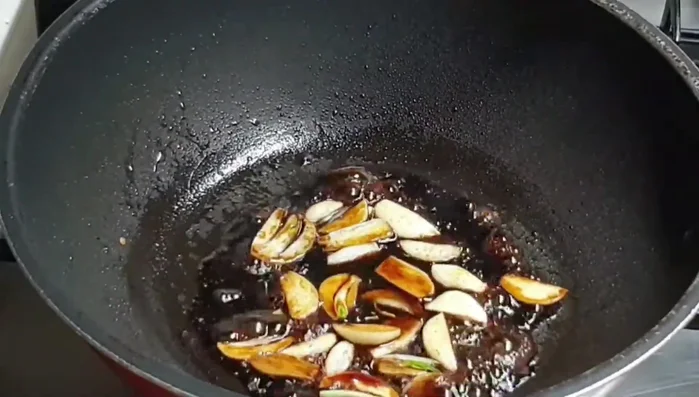 Cho cá cơm đã xào vào chảo, đảo đều.