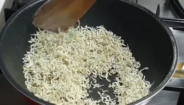 Xào cá cơm sơ qua cho đều trên chảo với lửa vừa. Lưu ý: xào lửa vừa để cá không bị cháy.