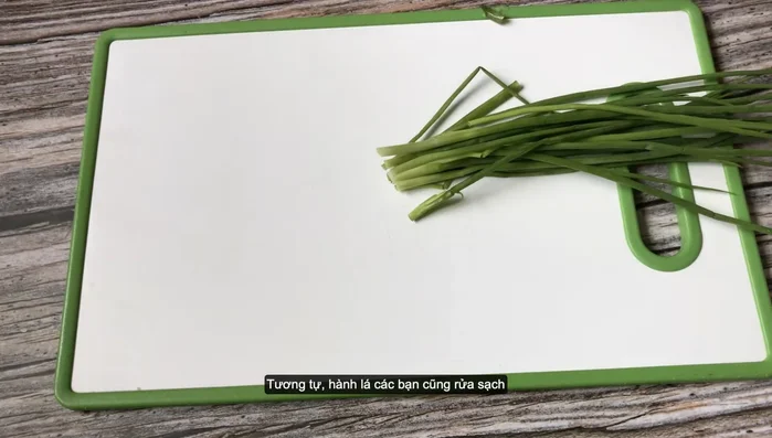 Rửa sạch hành lá, cắt bỏ phần đầu trắng, cắt khúc.