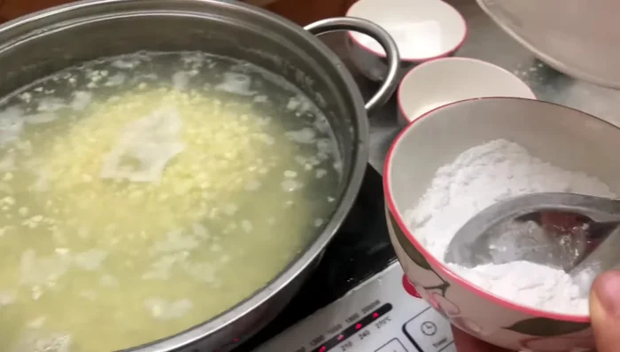 Cho bột năng vào, khuấy đều tay đến khi chè có độ sánh vừa phải.