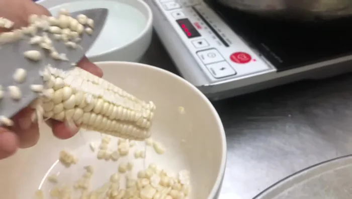 Tách hạt ngô ra khỏi bắp ngô.