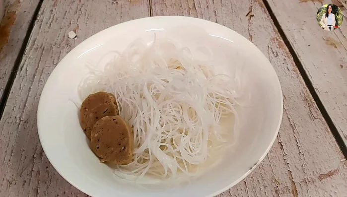 Cho hủ tiếu, thịt, giá, hẹ vào tô, chan nước dùng.