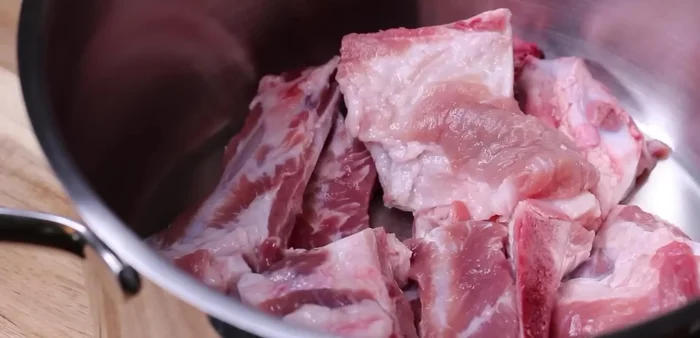 Nấu xương heo: Rửa sạch 1kg xương heo, cho vào nồi với 1 lít nước và 1 muỗng cà phê muối. Đun sôi, vớt bọt, rồi xả nước lạnh lại cho sạch.