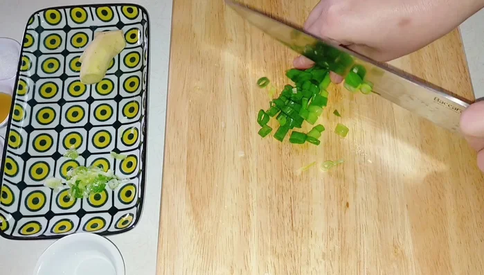 Cắt nhỏ hành lá và gừng thành sợi.
