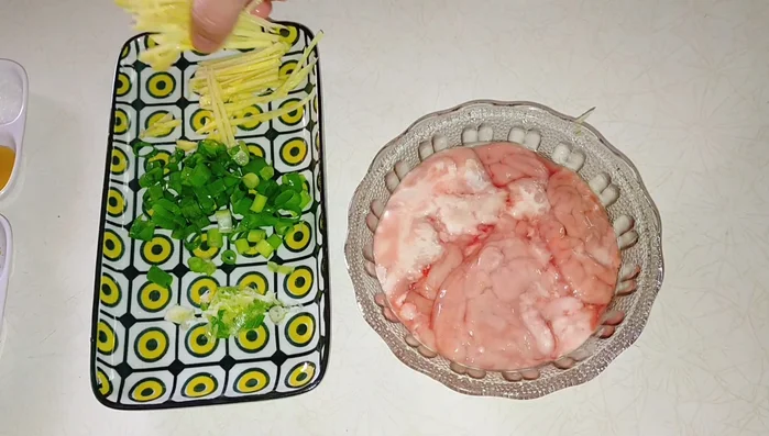 Cho 1 muỗng cà phê rượu nấu ăn, nửa củ gừng và hành lá trắng vào tô cùng ốc heo.