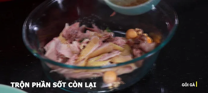 Thêm thịt gà luộc xé nhỏ vào trộn đều, để khoảng 2 phút cho ngấm gia vị.