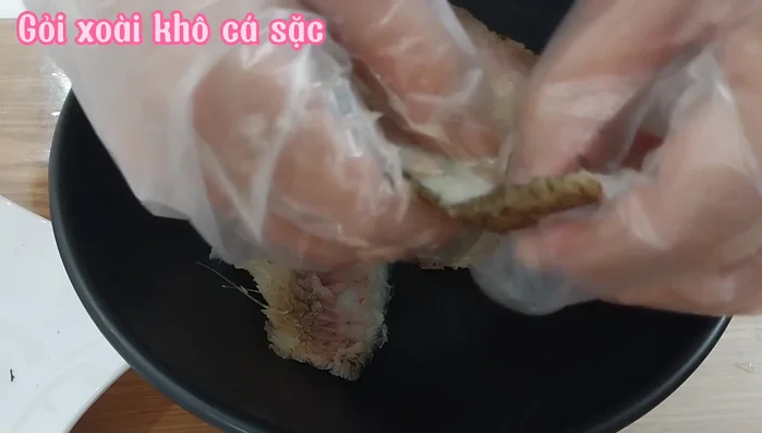 Xé cá khô thành sợi nhỏ.