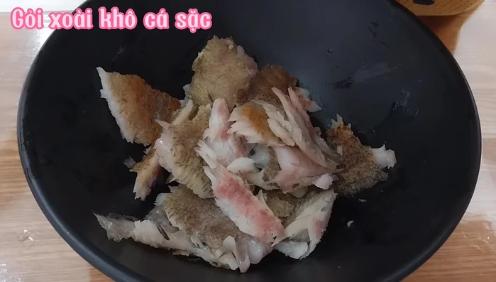Để giảm độ mặn, cho đường và chanh vào cá khô, trộn đều.