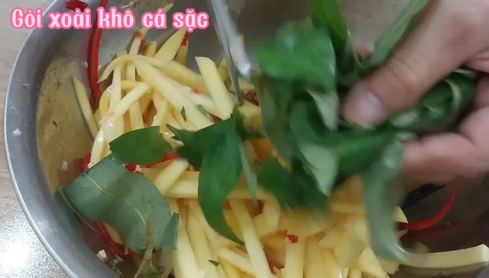 Thêm rau răm và cá khô vào gỏi, trộn đều.