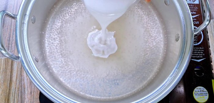 Thêm 150g đường, 1/2 muỗng cà phê muối và 400ml nước cốt dừa vào hỗn hợp bột báng, khuấy đều. (309.789)