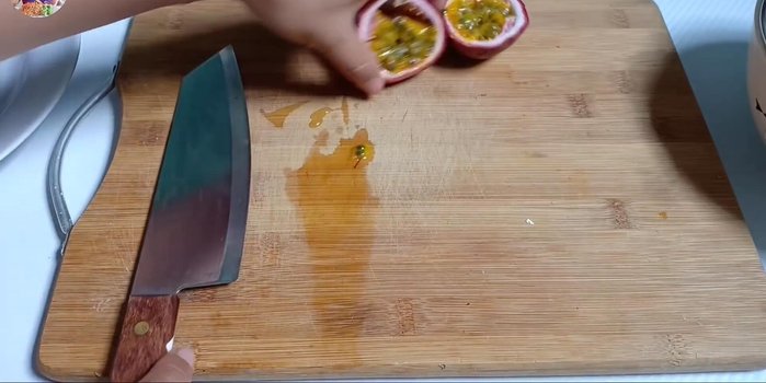 Cắt đôi chanh dây, nạo lấy phần cơm và dùng rây lọc lấy nước cốt. (103.11)