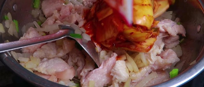 Cho kimchi vào xào cùng thịt cho đến khi kimchi thấm vào thịt (khoảng 2-3 phút).