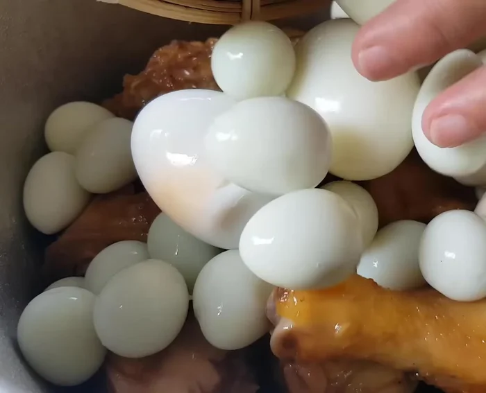 Kho thịt gà và trứng: Cho thịt gà, trứng vào nồi. Thêm nước dừa, nước lọc, muối, nước mắm, bột ngọt, tương ớt. Đun sôi, hớt bọt, hạ lửa nhỏ, kho đến khi nước cạn bớt, thịt mềm, trứng thấm.